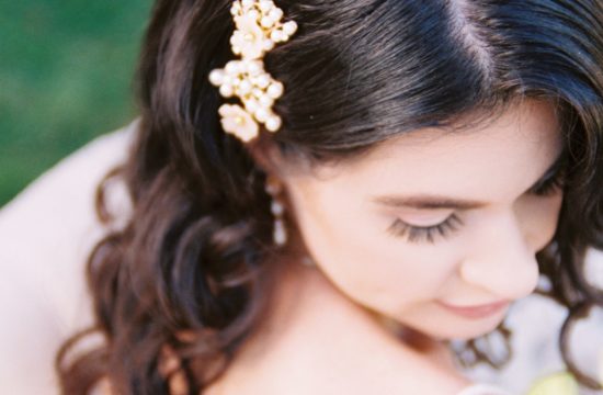 a bride looks to the ground showcases her headpiece