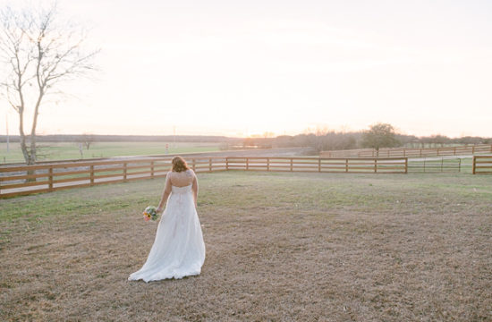 a bride walks towards an sunset in an open field