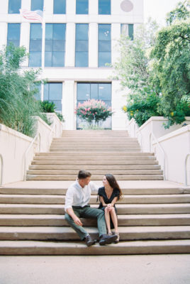 a couple sits on the stairs looking at each other during their engagement session, this image is bewing used a t the feature image of the Lady Bird Lake engagement shoot