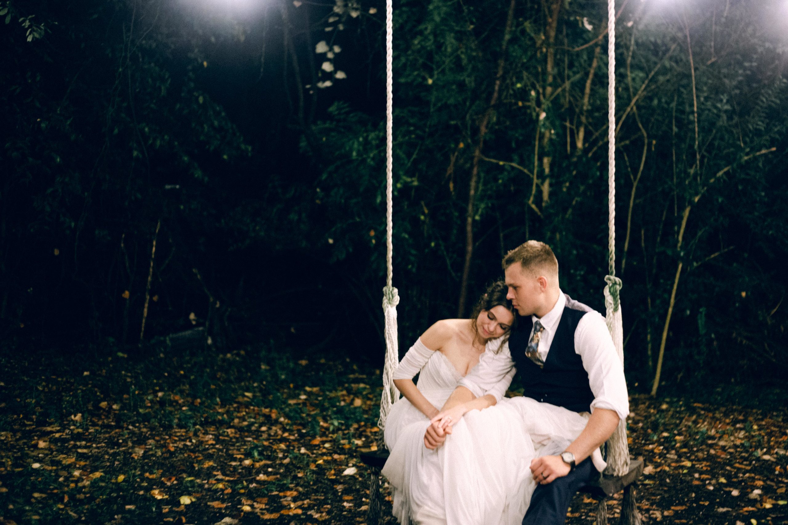 Color image of a bride and groom enjoying just being married and taking bridal photos at night on a swing at Mercury Hall a venue in Austin Texas. Rae Allen website cover image