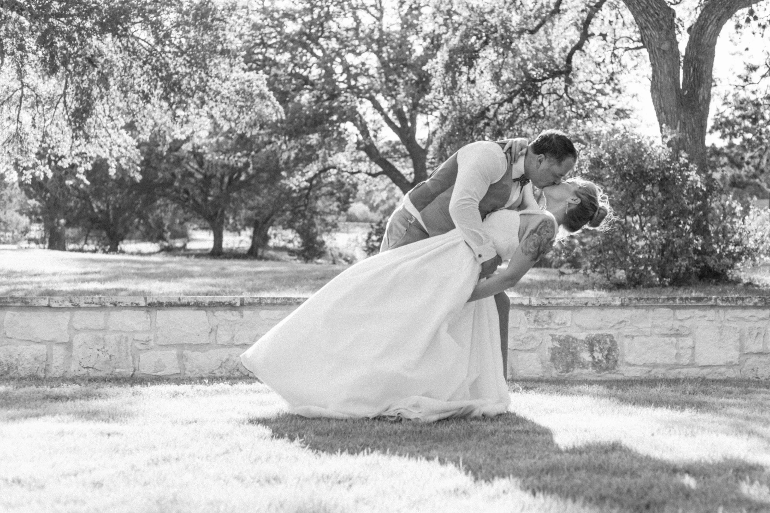 Rae Allen Photography | black and white images of a groom dipping his bride in an open field with Rae Allen Photography
