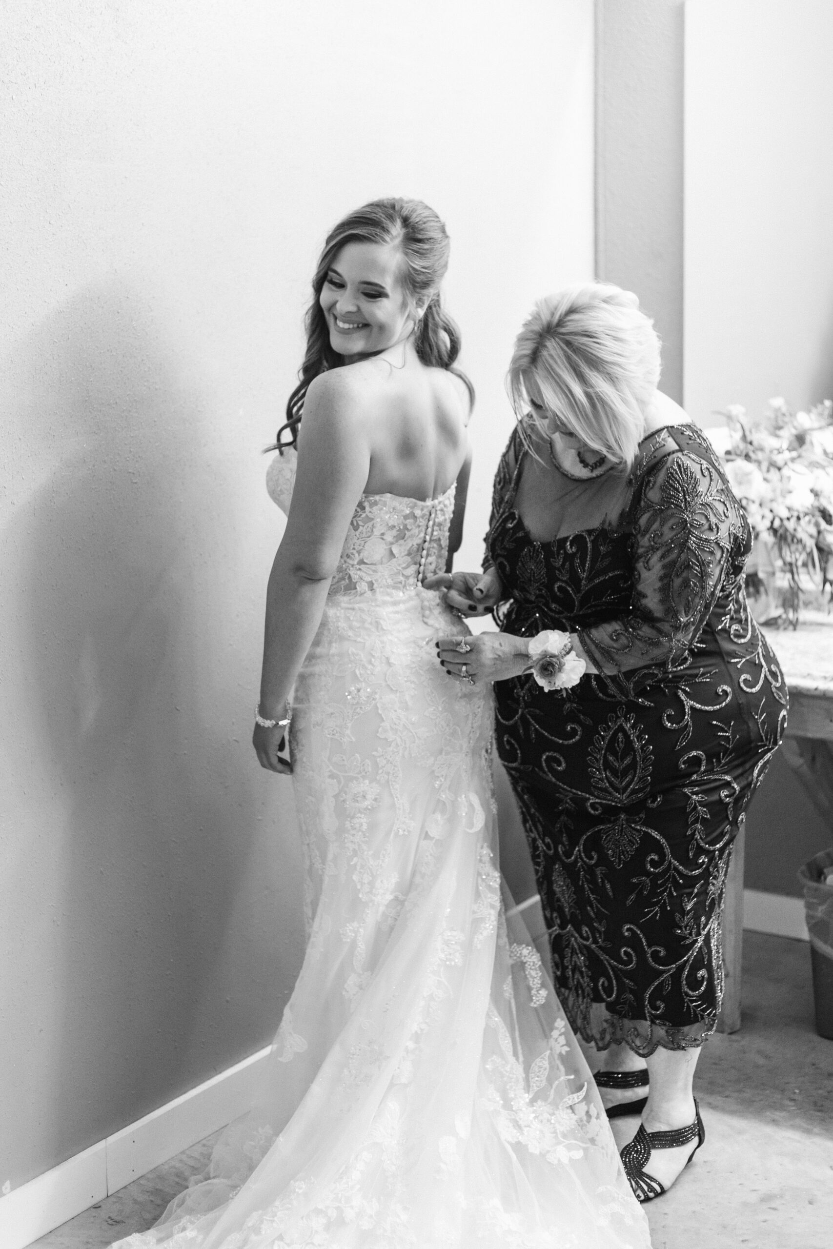 Rae Allen Photography | Mom zipping up the bridal gown