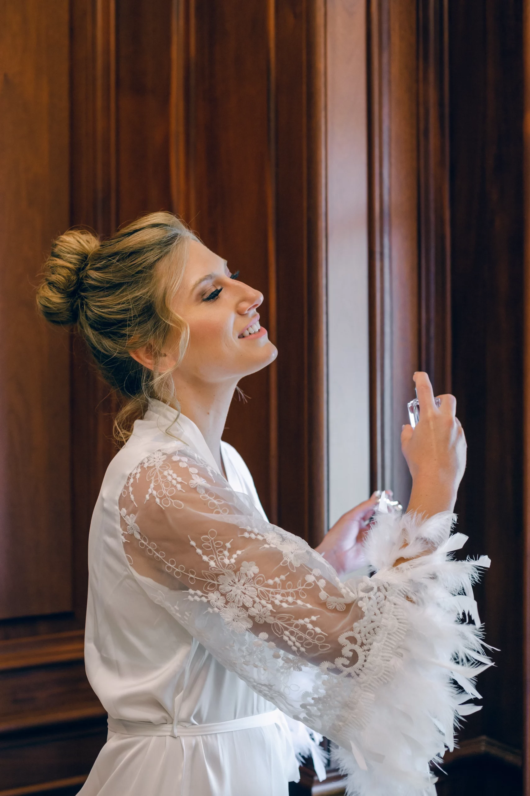 Rae Allen Photography | The bridal spraying perfume on herself in the bridal suite