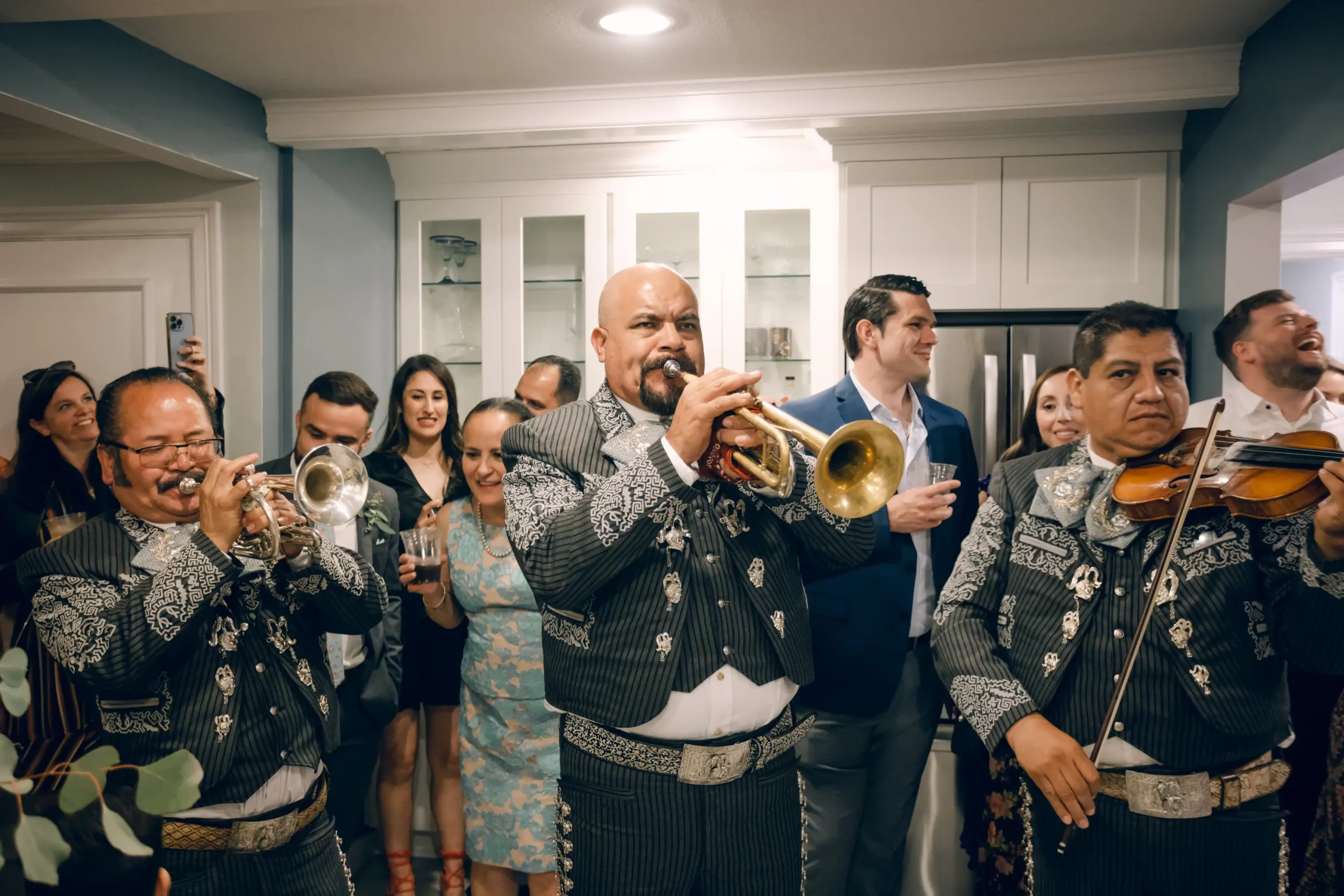 A performer play s the trumpet in the living room at the chavez wedding