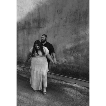 a black and white image of a COUPLE AGAINST A STUCCO BACKDROP DURING their Engagement SESSION | Rae Allen photography | engagement guide