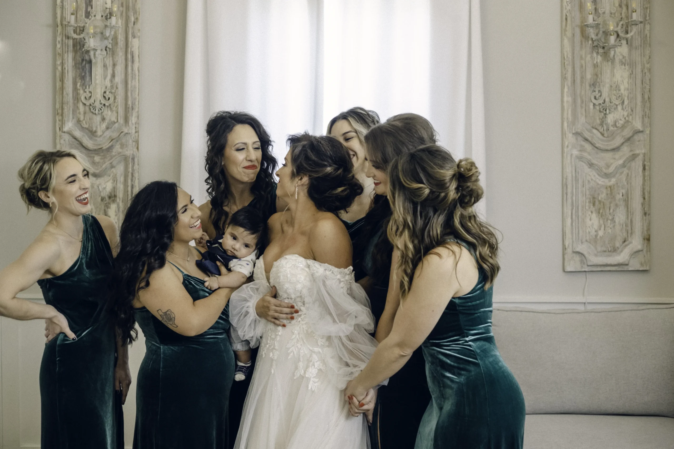 Rae Allen Photography | A group shot of the bride at old Bethany taking a photo with her bridesmaids in the bridal suite before the wedding