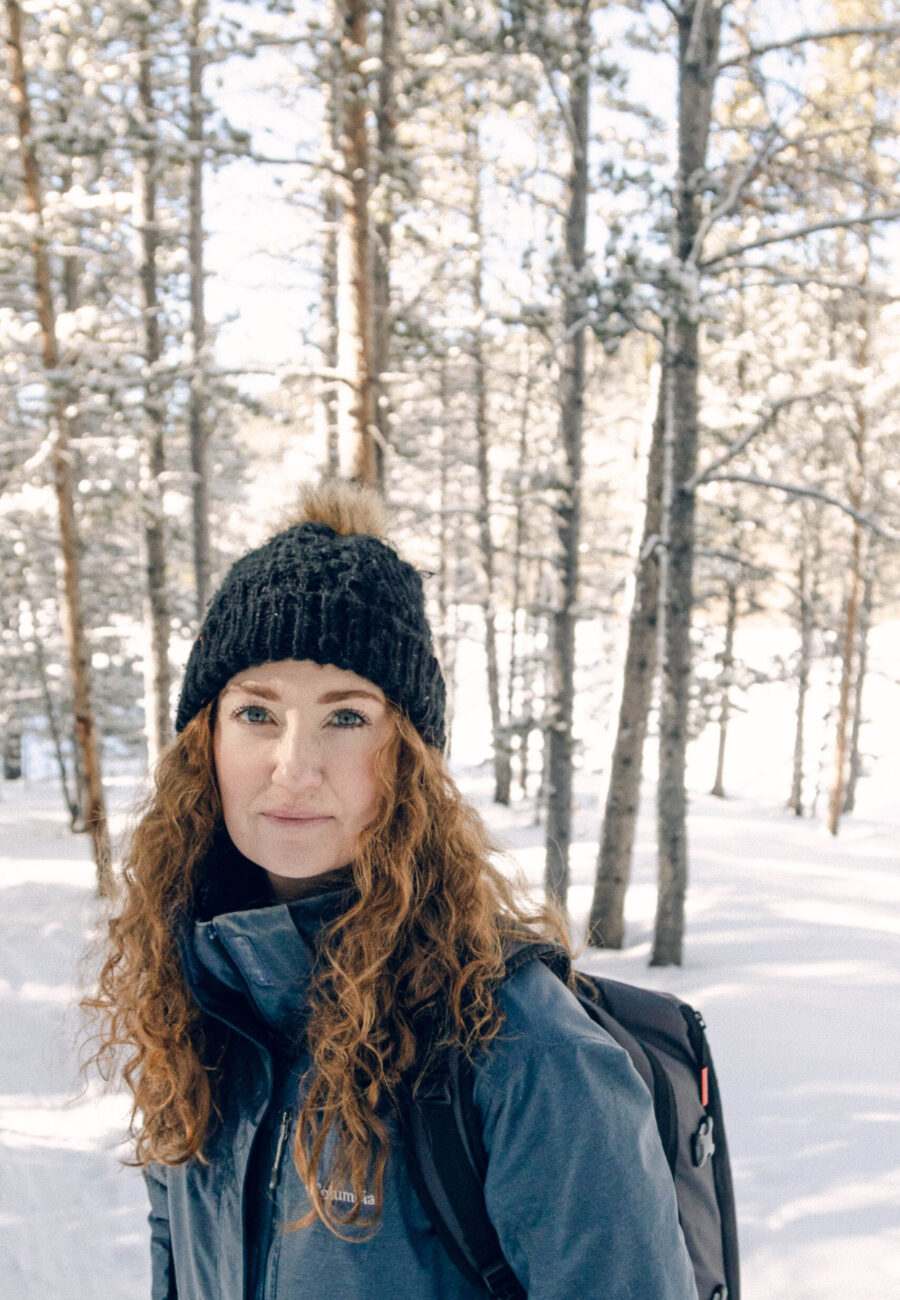 A feature image of Rae Allen. Shes look at the camera in colorado, she is wearing a black beany and a blue coat